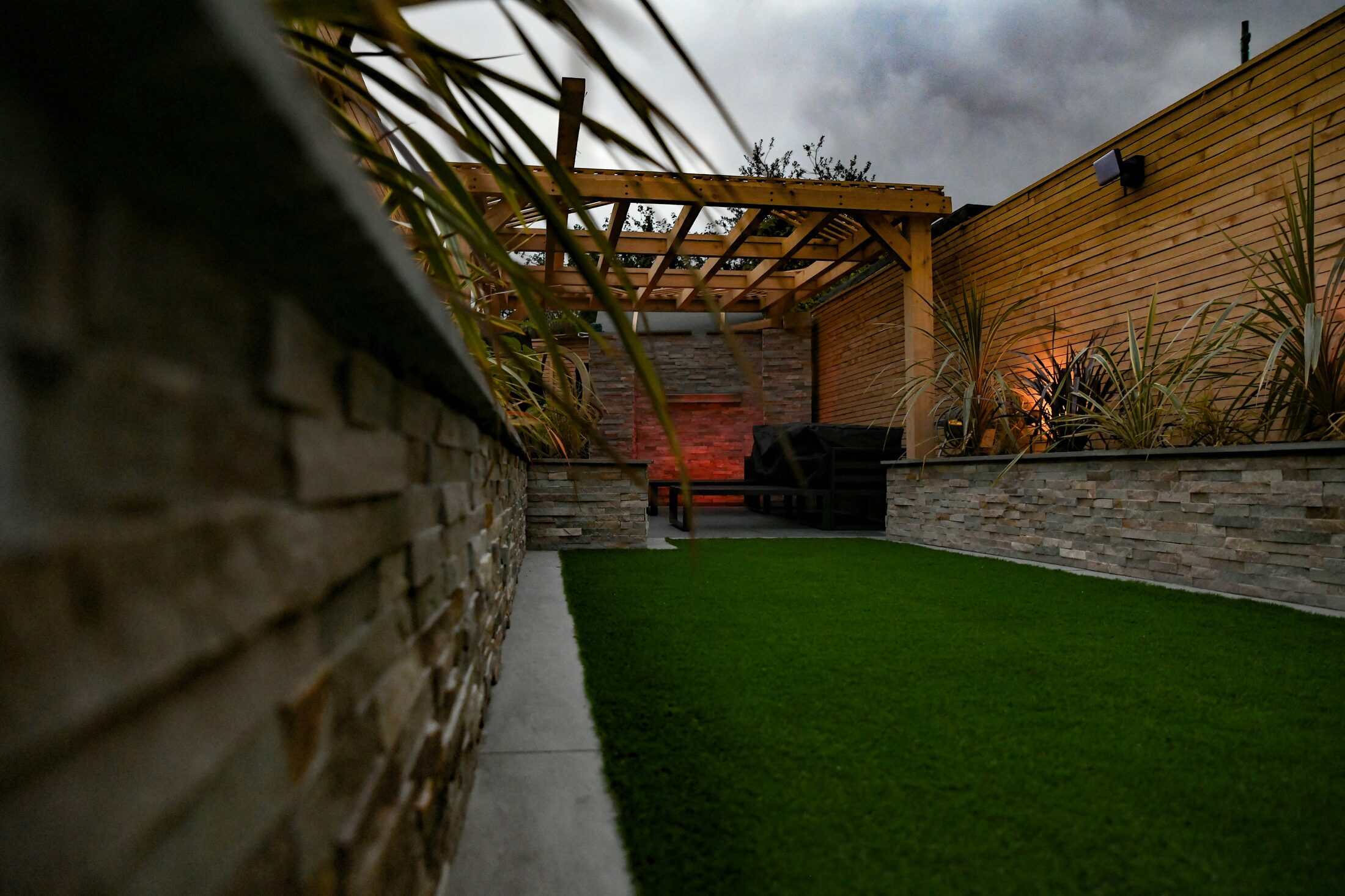 Contemporary garden with timber slatted fencing and a pergola